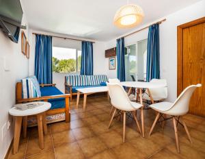 卡拉维尼耶斯Globales Apartamentos Cala Viñas ONLY ADULTS 16的客厅配有桌椅和沙发