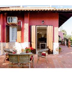 奥古斯塔Villa Angela的前面有一张桌子和椅子的红色房子