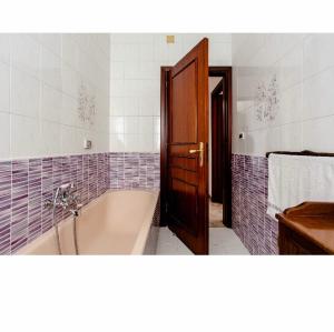 奥古斯塔Villa Angela的一间带浴缸的浴室和一扇木门