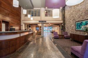 里贾纳桑德曼酒店及套房－里贾纳的酒店大堂设有酒吧和紫色椅子