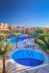 亚喀巴Marina Plaza Hotel Tala Bay的享有棕榈树和建筑度假村泳池的顶部景致