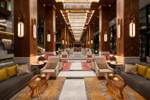 伊斯坦布尔Mövenpick Hotel Istanbul Asia Airport的大厅,设有沙发和桌子