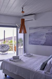 RóziaSyros Luxury Living的一间卧室配有一张床,享有海景