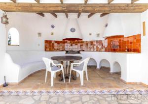 卡尔佩Inftour La Fustera Villa的厨房配有桌椅和炉灶。