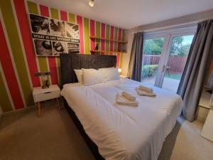 布里斯托Kingsfield House by Cliftonvalley Apartments的一间卧室配有一张大床和毛巾