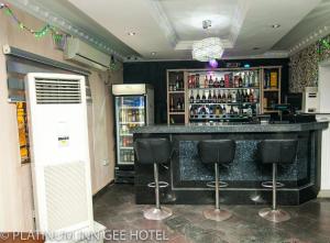 Suru LerePlatinum Inn Gee Hotel的一间酒吧,里面设有黑酒吧凳子