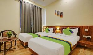 乌代浦Tripli Hotels Le Shelton的酒店客房设有两张床和一张桌子。