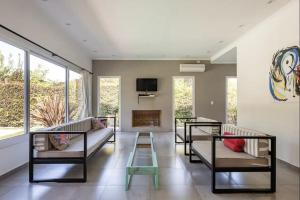 Del VisoDivina casa con parque pileta en mini barrio cerrado.的客厅配有3张沙发和1台电视