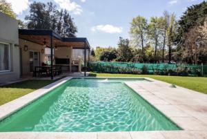 Del VisoDivina casa con parque pileta en mini barrio cerrado.的一座房子后院的游泳池