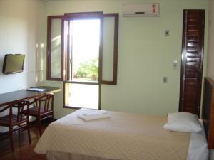 坎皮纳斯Casa do Professor Visitante Unicamp的一间卧室配有一张床、一张书桌和一个窗户。