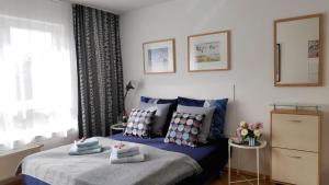 科瑟罗Strandnahe Ferienwohnungen mit Garten的一间卧室配有蓝色的床、枕头和窗户