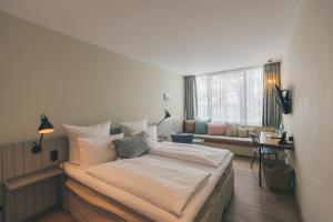 石勒苏益格Hotel Strandleben的一间卧室配有一张大床和一张沙发