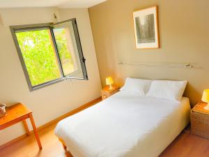 ArignacLe Domaine d'Arignac的卧室配有白色的床和窗户。