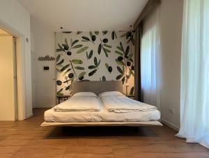 加尔达湖滨Agritur Fiore d'Ulivo的一间卧室配有一张带花卉墙壁的床