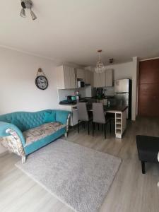 拉塞雷纳Departamento en La Serena的一间带蓝色沙发的客厅和一间厨房