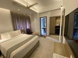 达卡Priyo Nibash Stylish Residential Hotel的一间带大床的卧室和一间客厅