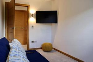 AuchenblaeThe Cottage - spacious getaway with stunning views的一间房间,配有一张床和墙上的电视