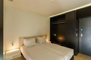 波尔图N Apartments - Chã的卧室配有白色的床和黑色橱柜。
