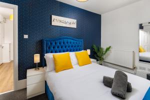 利物浦FLATZY - Lovely Sefton Park Retreat的蓝色卧室配有一张带黄色枕头的大床