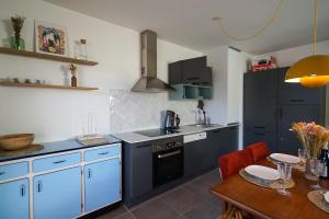 杜萨尔The Azalea beautiful quiet apartment for 4 people!的厨房配有蓝色橱柜和木桌