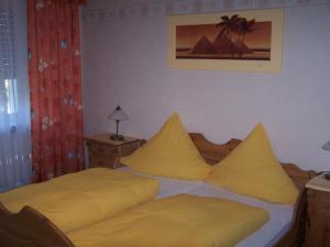 TraisenZur Rotenfelsstube的一间卧室配有一张带黄色床单和枕头的床。