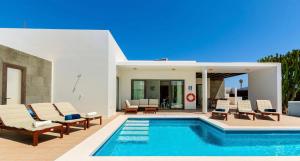 普拉亚布兰卡Jacks Place Villa PlayaBlanca Pool Spa的一个带躺椅的游泳池以及一座房子