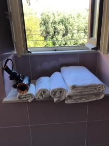 圣安吉洛Maison de Charme Iommella的浴室的架子,带毛巾和窗户