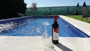 DoloresEco Resort Costa Blanca的一瓶葡萄酒和一杯游泳池旁的玻璃