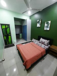 巴生HOMESTAY DR. Z (MUSLIM HOMESTAY)的一间卧室,在绿色的墙上配有一张大床