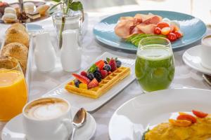 加尔达湖滨Lido Palace - The Leading Hotels of the World的餐桌上摆放着早餐食品和饮料