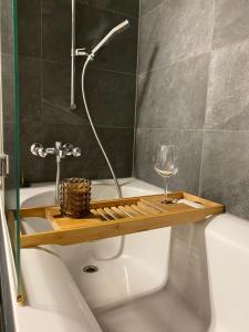 巴塞尔Stylish two-floor apartment in a heart of Basel的带浴缸和葡萄酒玻璃的浴室