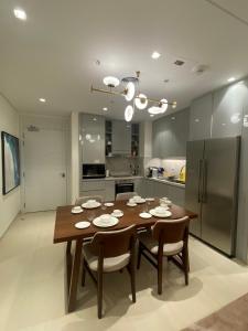 富查伊拉Two Bedroom Apartment Address Residence - Fujairah的厨房配有木桌、椅子和冰箱