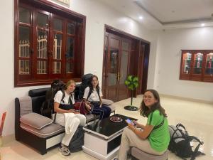 河内Hanoi Airport Suites Hostel & Travel的三个女人坐在房间里玩电子游戏