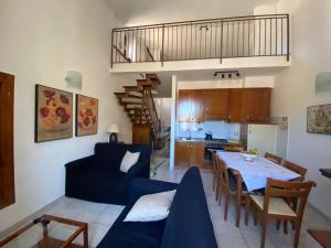 斯波莱托Mameli Suite的客厅以及带蓝色沙发和桌子的厨房。