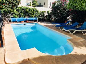 夏约法Private pool 'Villa Vibe Tenerife' sunset & ocean view的一个带两把椅子的游泳池和一个游泳池