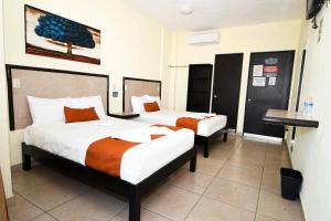 OcozocuautlaHotel los faroles的酒店客房配有两张床和一张书桌