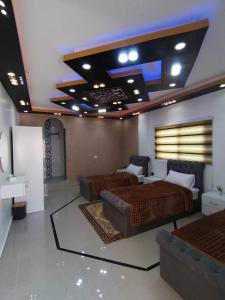 瓦迪穆萨Petra paradise home的一间卧室设有两张床,天花板上配有电视。