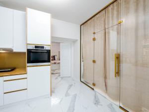 琴斯托霍瓦Apartament Gold Aleja NMP 8 - Free parking的厨房配有白色橱柜和玻璃冰箱
