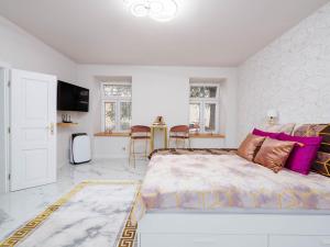琴斯托霍瓦Apartament Gold Aleja NMP 8 - Free parking的一间卧室配有一张带紫色枕头的大床