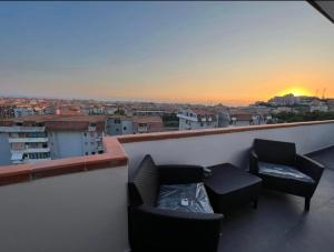 斯卡莱阿Residence Borghi的阳台配有两把椅子和一张沙发,享有日落美景。