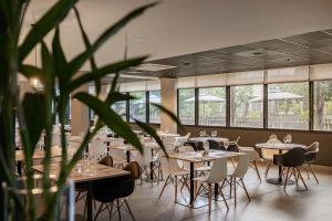 卡诺阿斯Intercity Canoas的一间设有桌椅和盆栽的餐厅