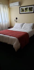 科洛尼亚-德尔萨克拉门托Hotel Sol Colonia的一间卧室配有一张带红色毯子的大床