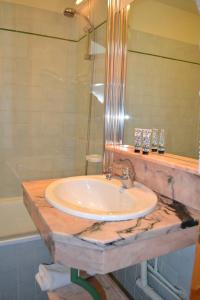 葱仁谷Résidence Montana Premier的一间带水槽和玻璃淋浴的浴室