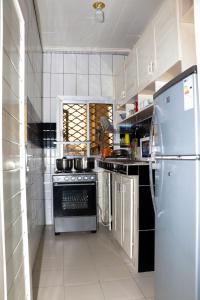 杜阿拉ENJOY n RELAX的厨房配有炉灶和冰箱。