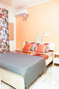 杜阿拉ENJOY n RELAX的一间卧室配有带橙色和蓝色枕头的床