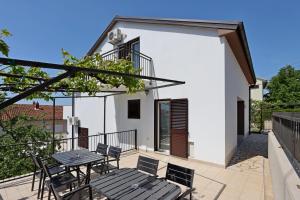 塞尔瑟Apartments and rooms with parking space Selce, Crikvenica - 2362的阳台的天井配有桌椅