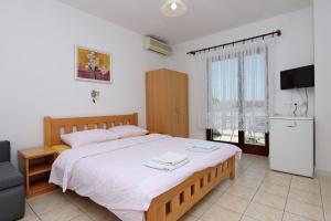 塞尔瑟Apartments and rooms with parking space Selce, Crikvenica - 2362的一间卧室配有一张大床和电视