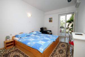 塞尔瑟Apartments and rooms with parking space Selce, Crikvenica - 2379的一间卧室配有一张带蓝色棉被的床