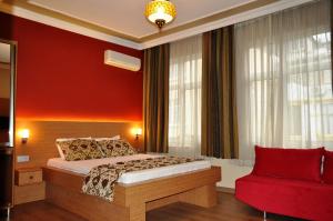 伊斯坦布尔古董酒店的一间卧室设有一张床和红色的墙壁