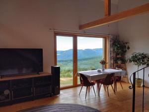特伦钦Nature Homestay的一间带桌子和大窗户的用餐室